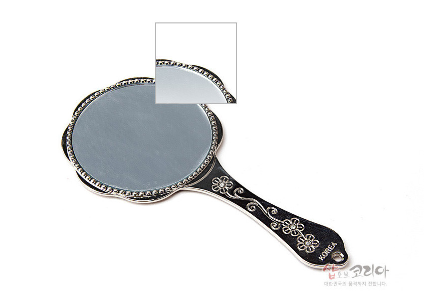 [텍스트: KOREA] 금속 재질의 손잡이 손거울, 손잡이와 테두리에 음각된 매화와 나비 문양, 은은한 자개 느낌의 광택 장식