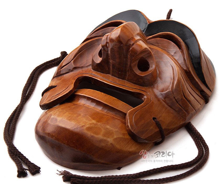 [텍스트: 샵오브코리아 대한민국의 품격까지 전합니다.] 광택 있는 원목을 깊이 있게 조각해 표현한 하회 양반탈, 짙은 갈색 나뭇결과 흑색 도포, 입체적인 주름과 질감 강조한 전통 목가면 구성