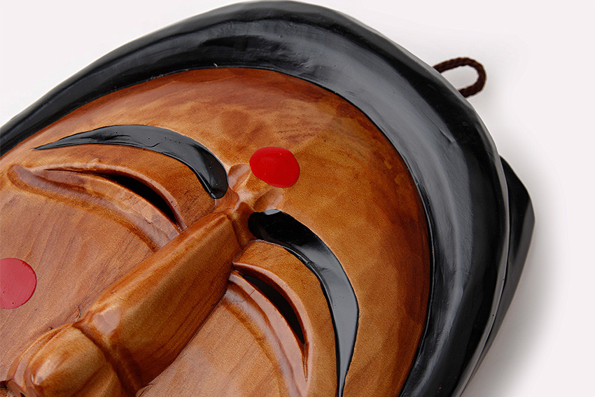 광택 있는 원목에 정교한 조각 기법을 더한 하회탈 부분 확대, 짙은 갈색 바탕과 검은 머리띠·눈썹, 붉은 점 장식이 대비를 이루는 전통 목가면 표현