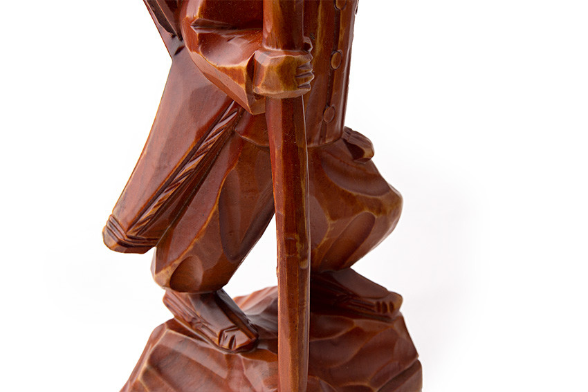 목각인형-지게를 진 조각상 광택 있는 갈색 목재로 조각된 지게 진 노인의 하반신과 지팡이 부분, 면을 살린 조각 기법과 자연스러운 나뭇결 대비가 돋보이는 목각 인형상