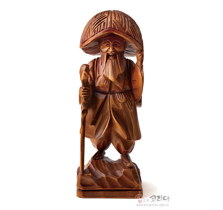 [텍스트: 샵오브코리아 대한민국의 품격까지 전합니다.] 원목의 자연스러운 나뭇결을 살린 김삿갓 형상 목각인형, 삿갓과 지팡이, 주름진 도포를 정교한 입체 조각으로 표현한 전통 조각상