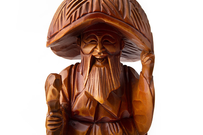 광택 있는 갈색 원목에 입체 조각 기법을 더해 김삿갓의 삿갓, 지팡이, 수염과 주름진 의복을 세밀한 음각과 양각으로 표현한 목각 인형 장식품