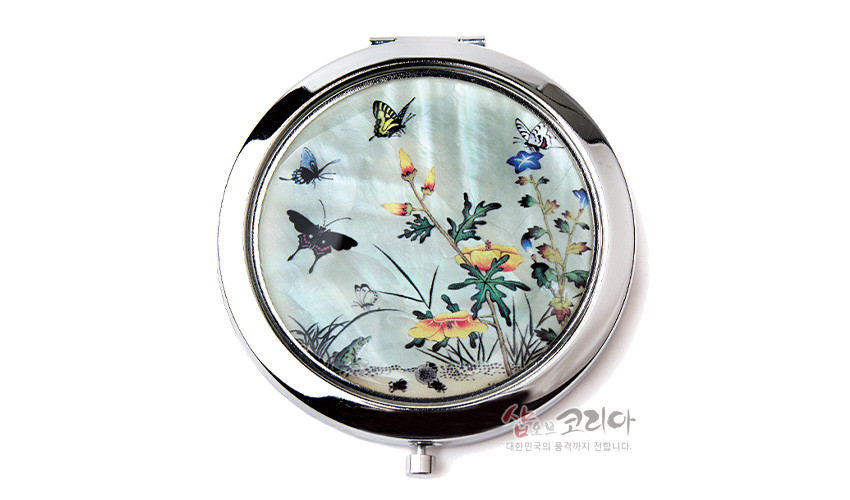 [텍스트: 샵오브코리아 대한민국의 품격까지 전합니다.] 금속 테두리에 천연 자개 상감 기법으로 꽃과 나비, 풀벌레가 어우러진 초충도 문양 원형 손거울 디자인