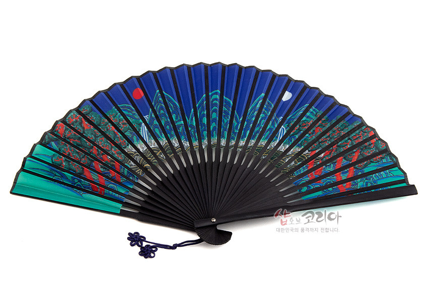 [텍스트: 샵오브코리아 대한민국의 품격까지 전합니다.] 짙은 남색 종이에 일월오봉도 민화 문양을 채색한 접이식 부채, 흑색 살대와 남색 매듭 장식 특징