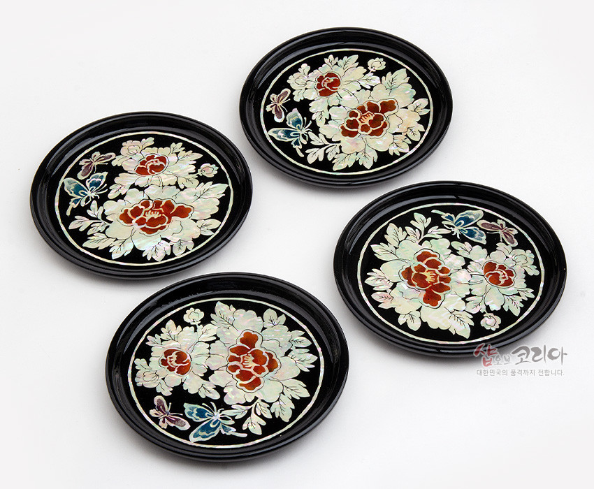 [텍스트: 샵오브코리아 대한민국의 품격까지 전합니다] 흑색 옻칠 바탕 위 자개 상감 기법으로 목단꽃과 나비 문양을 섬세하게 표현한 원형 나전칠기 컵받침 4종 세트 이미지