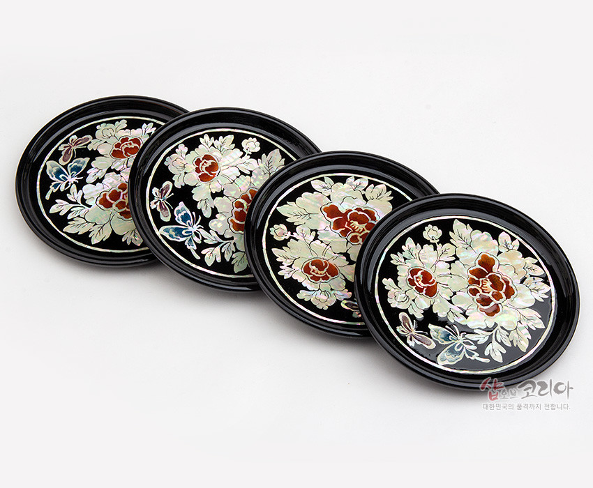 [텍스트: 샵오브코리아 대한민국의 품격까지 전합니다.] 흑색 옻칠 바탕에 자개 상감 기법으로 목단꽃과 나비 문양을 섬세하게 표현한 원형 나전칠기 컵받침 4종 세트 이미지