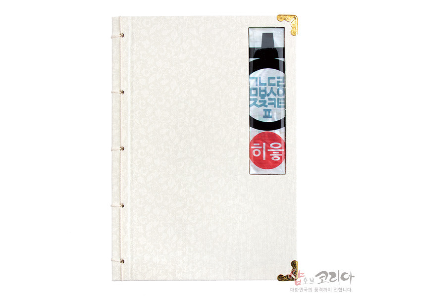 [텍스트: 히읗, 샵오브코리아 대한민국의 품격까지 전합니다.] 아이보리색 비단에 은은한 화문 문양을 넣고 측면 끈 제본과 금속 모서리 장식, 세로 창에 한글 히읗 디자인을 더한 전통 오침노트 이미지 설명