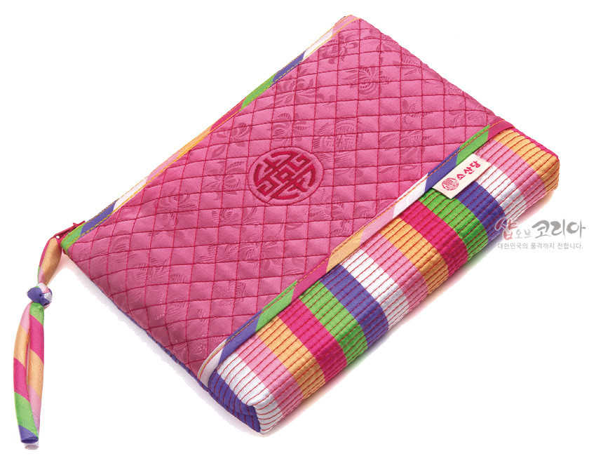 [텍스트: 소산당] 분홍색 비단 누비 바탕에 격자 누빔과 원형 수복문 자수, 하단 색동 줄무늬와 색동 끈 장식이 조화를 이룬 파우치 이미지 설명
