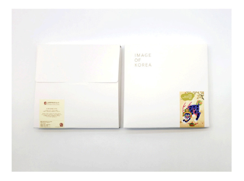 [텍스트: IMAGE OF KOREA] 흰색 종이 재질 봉투형 패키지에 민화 호랑이 일러스트 라벨을 부착한 심플한 디자인의 포장 구성