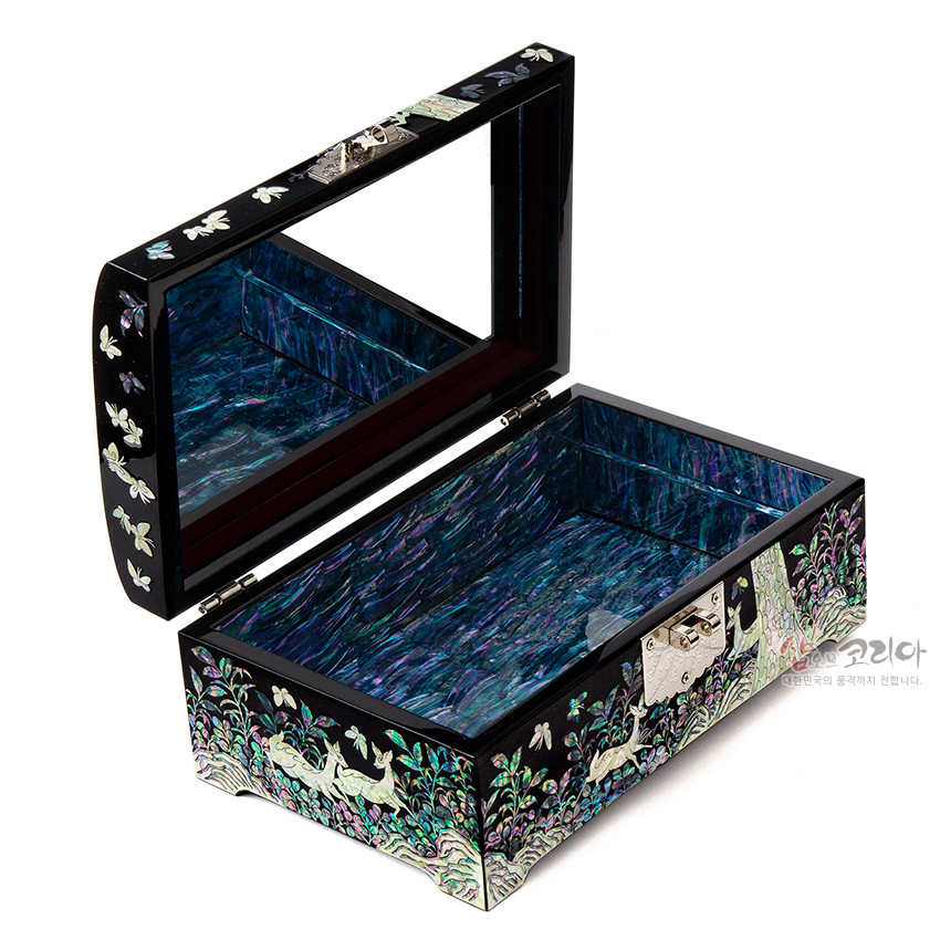 [텍스트: 샵오브코리아 대한민국의 품격까지 전합니다.] 자개 상감과 흑색 옻칠 위에 송학과 소나무, 난초 문양을 섬세히 새긴 보석함, 내부 오팔빛 자개 마감과 거울 장식으로 빛나는 전통 나전칠기 공예품 표현