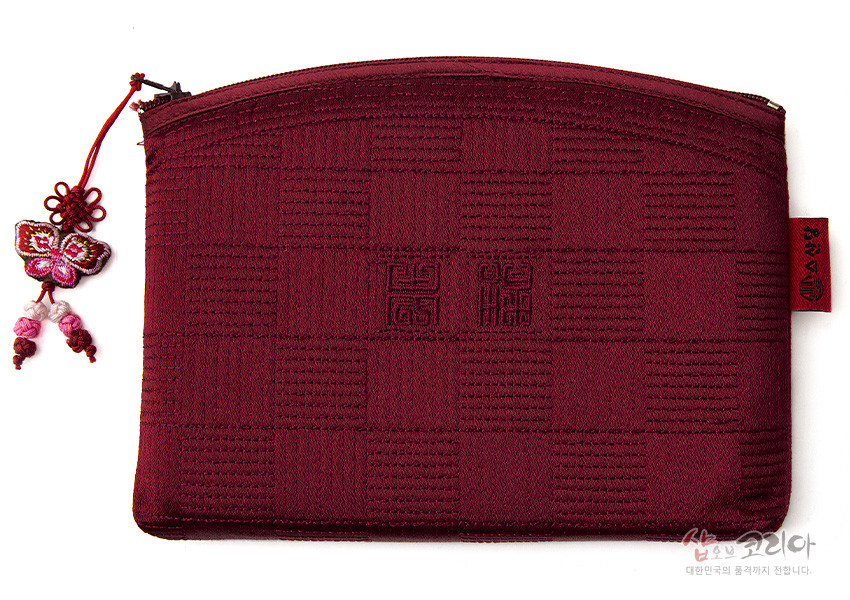 [텍스트: 샵오브코리아 대한민국의 품격까지 전합니다.] 적갈색 비단 누비 원단에 격자 짜임과 중앙 전통 문자 문양, 나비 자수 매듭 장식 지퍼 손잡이가 있는 파우치형 지갑 이미지 설명