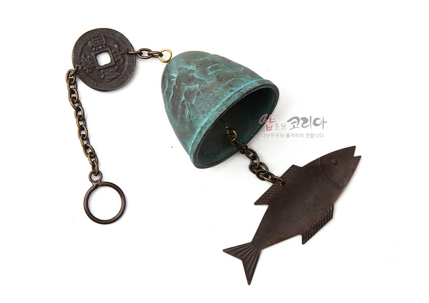 [텍스트: 샵오브코리아 대한민국의 품격까지 전달합니다.] 청록빛 산 모양 청동 종과 고대 동전 장식, 흑갈색 물고기 모양 추를 체인으로 연결한 전통 금속 풍경종 형태 이미지 설명