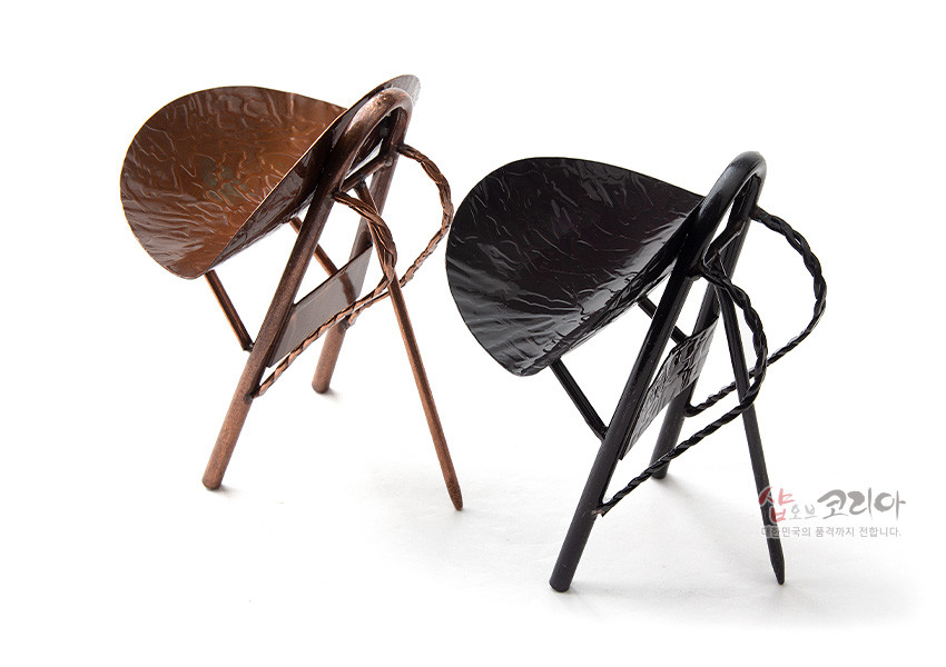 [텍스트: 샵오브코리아 대한민국의 품격까지 전합니다.] 유광 마감 황동 소재 미니 지게 소품, 갈색·검정 색상과 두드린 질감 음각 무늬, 꼬임 형태 지게 끈 장식 특징의 전통 공예 인테리어 오브제