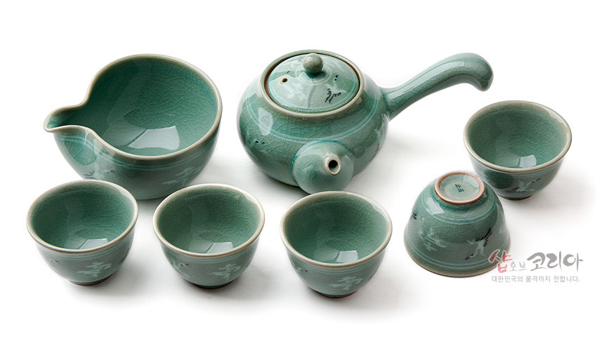 [텍스트: 샵오브코리아 대한민국의 품격까지 전합니다.] 청록색 고려청자 유약의 도자기 다기세트, 상감 운학문양과 자연스러운 균열무늬가 돋보이는 5인용 구성