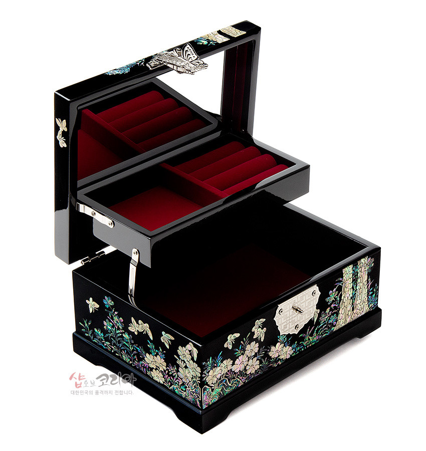 [텍스트: 샵오브코리아 대한민국의 품격까지 전합니다] 흑색 옻칠 위 자개 상감으로 소나무와 학, 꽃과 나비 문양을 수놓고, 내부는 붉은 비단 느낌으로 마감한 2단 구조 나전보석함 이미지설명