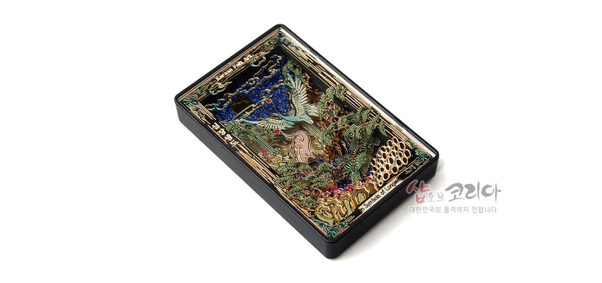 [텍스트: 샵오브코리아 대한민국의 품격까지 전합니다.] 금속 재질 입체 양각 기법으로 학, 소나무, 해, 구름, 거북 등 십장생도를 다채로운 금·녹·청색으로 표현한 직사각형 마그넷 디자인
