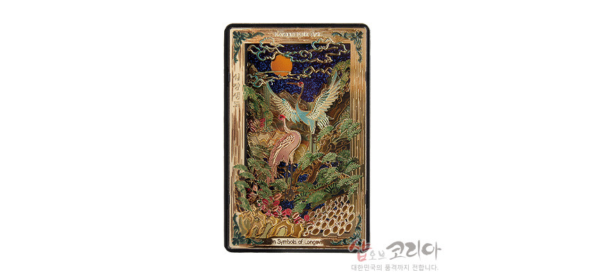 [텍스트: Korean folk arts / Symbols of Longev] 금속 재질 위 입체 양각 기법으로 학, 소나무, 해, 구름, 파도 등 십장생 문양을 다채로운 금빛과 녹색, 남색으로 채색한 직사각형 마그넷 형상