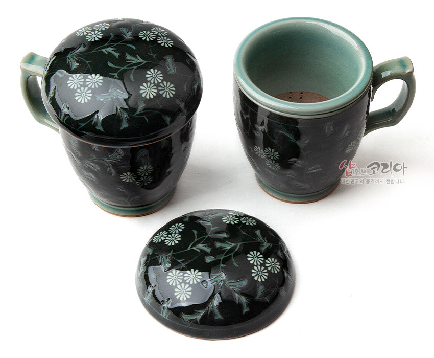 [텍스트: 샵오브코리아 대한민국의 품격까지 전합니다.] 짙은 녹색 유약 위 백색 국화와 넝쿨 상감 문양이 둘러진 도자기 머그 다기잔과 뚜껑 세트 모습