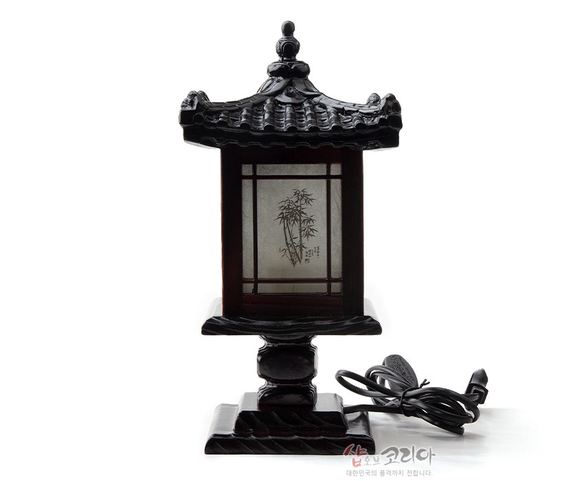 [텍스트: 샵오브코리아 대한민국의 축제를 전합니다.] 짙은 흑색 목재와 기와 지붕 조각, 반투명 한지 면에 대나무 문양이 인쇄된 전통 미니 좌등 디자인