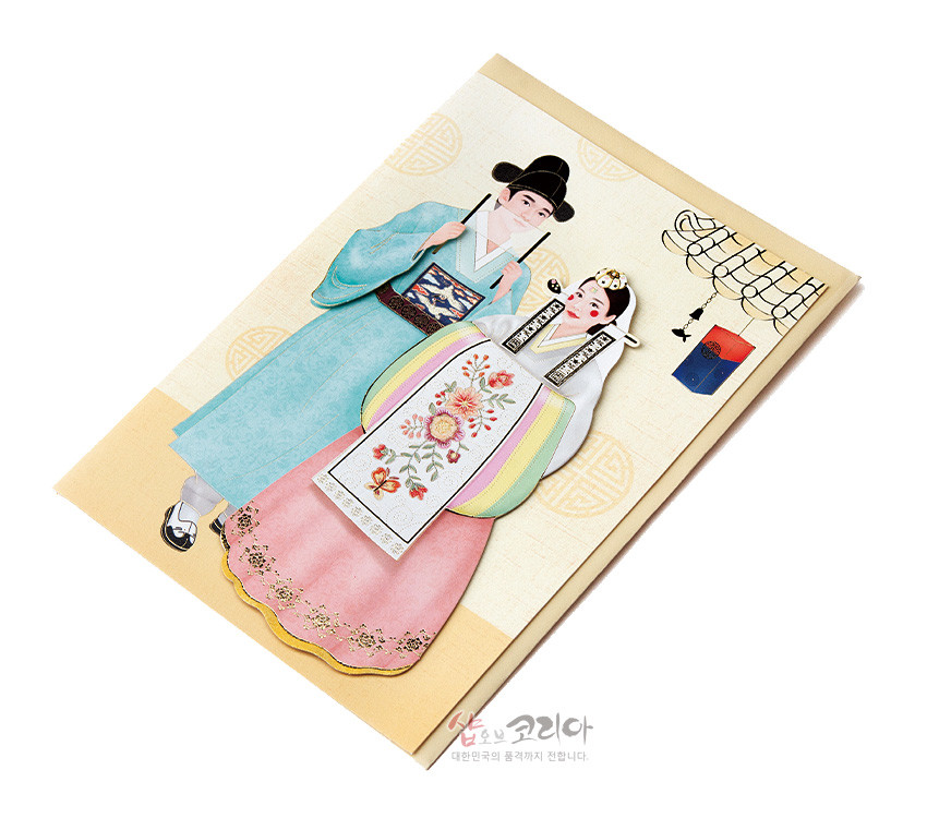 [텍스트: 샵오브코리아 대한민국의 품격까지 전합니다.] 전통 혼례 한복 입체 카드, 파스텔 색 한복과 꽃자수 장식, 노리개·기러기 장식 및 전통 문양 배경 표현