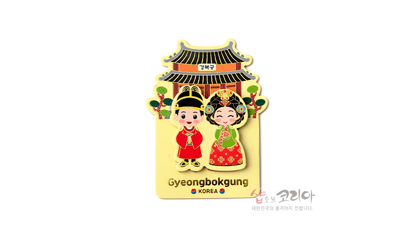 [텍스트: 경복궁 / Gyeongbokgung / KOREA / 샵오브코리아 대한민국의 품격까지 전합니다.] 전통 혼례 예복 입은 남녀와 경복궁 전각을 형형색색 금속 입체로 표현한 자석, 홍색·녹색·금색 대비와 단순화된 민화풍 문양 장식 이미지