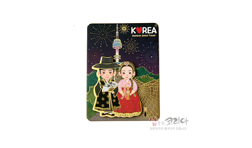 [텍스트: K♥REA Namsan Seoul Tower] 야경 속 불꽃놀이 배경 위 금속 재질 전통 혼례 예복 남녀 입체 마그넷, 검정·홍색 한복과 금색 장식 대비가 돋보이는 구성