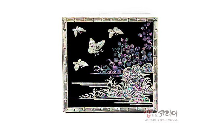 [텍스트: 샵오브코리아 대한민국의 품격까지 전합니다.] 흑색 옻칠 바탕에 자개 상감 기법으로 표현된 나비와 수풀, 기암괴석 문양, 가장자리 전통 기하학 테두리 장식 이미지