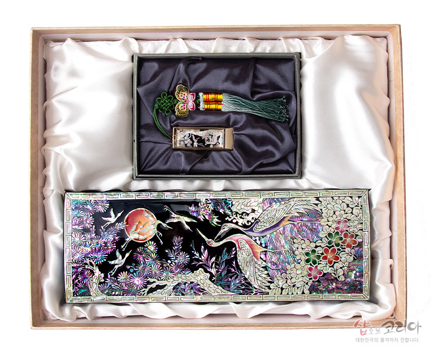 [텍스트: 샵오브코리아 대한민국의 품격까지 전합니다] 자개 상감과 옻칠 기법의 송학‧국화 문양 필함과 USB, 비단 술 장식의 오색 광택이 조화를 이룬 세트 구성 이미지 설명