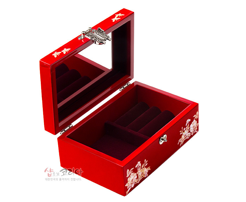 [텍스트: 샵오브코리아 대한민국의 품격까지 전합니다.] 붉은 옻칠 바탕에 자개 상감으로 모란과 나비 문양을 장식하고, 내부는 벨벳 질감으로 마감한 직사각형 나전칠기 보석함 모습