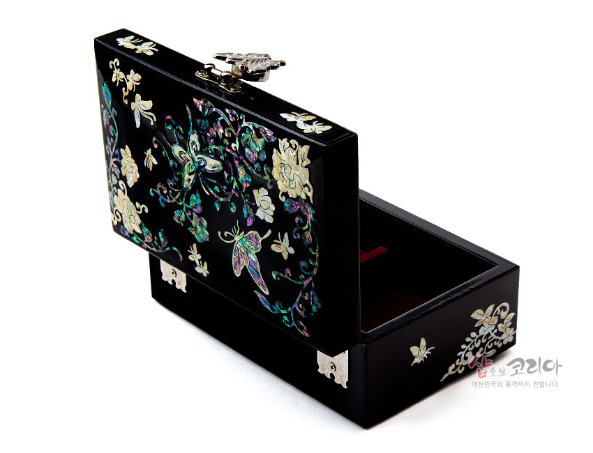 [텍스트: 샵오브코리아 대한민국의 품격까지 전합니다.] 흑색 옻칠 바탕 위 자개 상감 기법으로 나비와 모란 덩굴문을 화려하게 장식한 직사각형 보석함 디자인