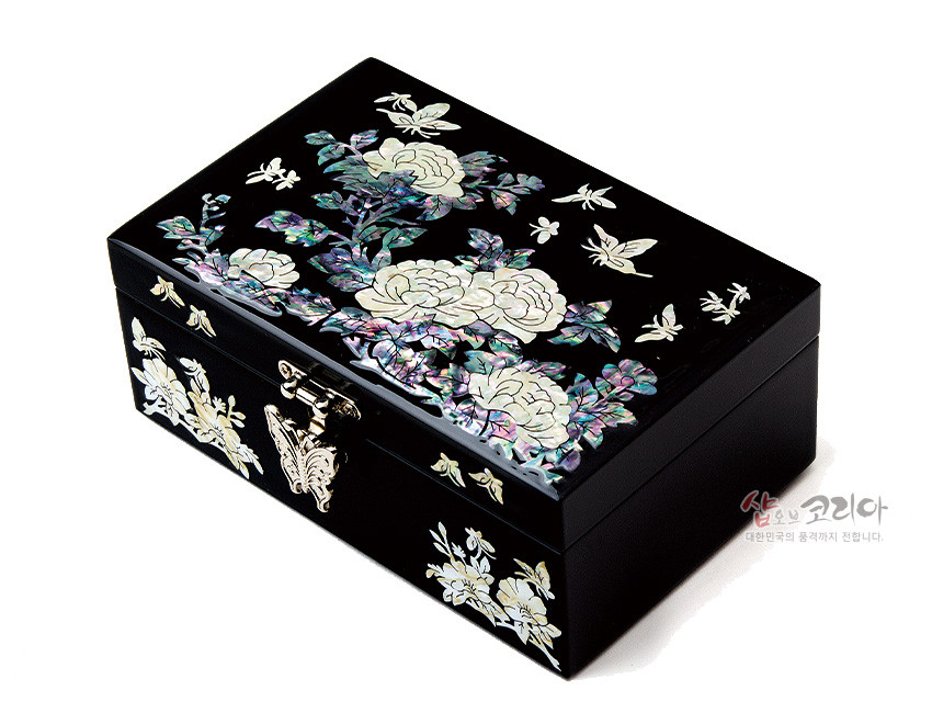[텍스트: 샵오브코리아 대한민국의 품격까지 전합니다.] 흑색 옻칠 바탕 위 자개 상감 기법으로 모란과 나비 문양을 정교하게 표현한 직사각형 금속 잠금장치 보석함 이미지 설명