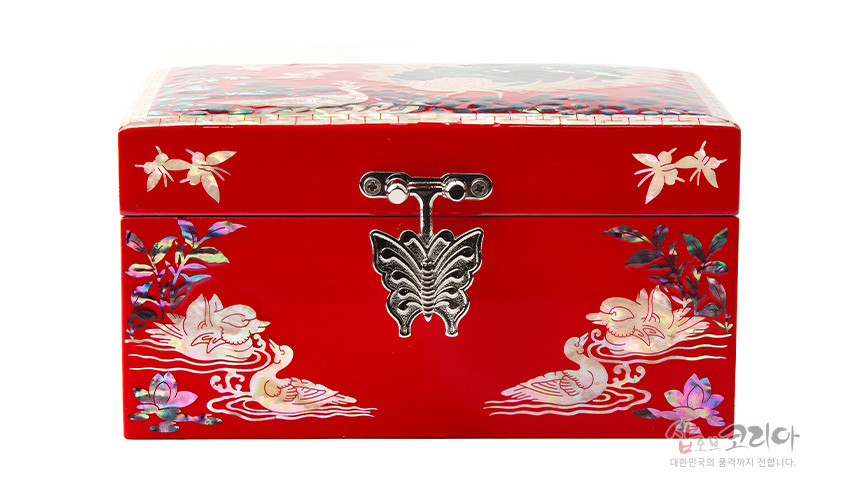 [텍스트: 샵오브코리아 대한민국의 품격까지 전합니다.] 붉은 옻칠 바탕 위 자개 상감된 연꽃과 물오리 문양, 중앙 나비 형 금속 장식이 돋보이는 직사각 나전칠기 보석함 정면 모습