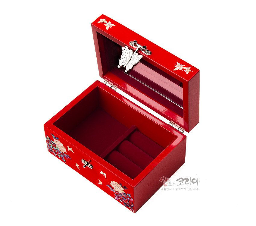 [텍스트: 샵오브코리아 대한민국의 품격까지 전합니다.] 적색 옻칠 바탕에 자개 상감 모란·나비·새 문양과 금속 나비 잠금장식을 더한 직사각형 내부 칸막이 보석함 이미지 설명