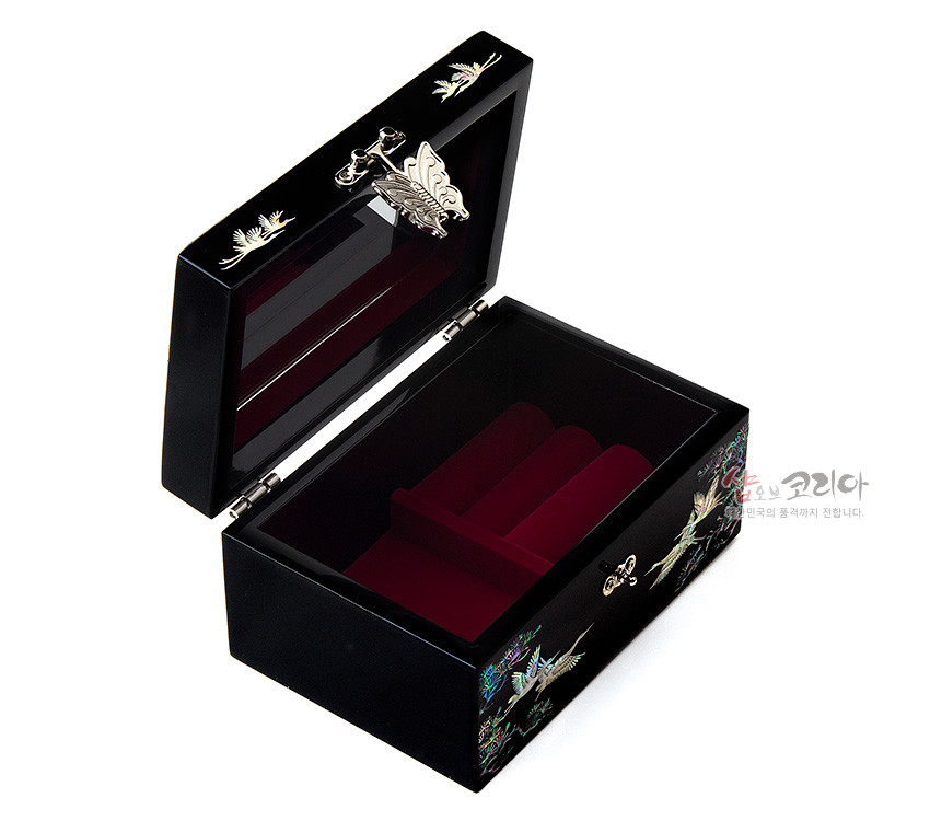 [텍스트: 샵오브코리아 한국의 품격까지 전합니다.] 흑색 옻칠 바탕에 자개 상감 송학·소나무 문양과 금속 나비 잠금장식, 내부 적색 벨벳 완충 구조 보석함 이미지
