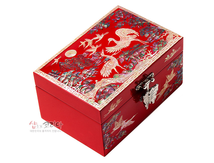 [텍스트: 샵오브코리아 대한민국의 품격까지 전합니다] 적색 옻칠 바탕 위 자개 상감으로 송학, 소나무, 만월과 산수 문양을 정교하게 표현한 직사각형 나전칠기 보석함, 나비 모양 금속 잠금장식 포인트 디자인