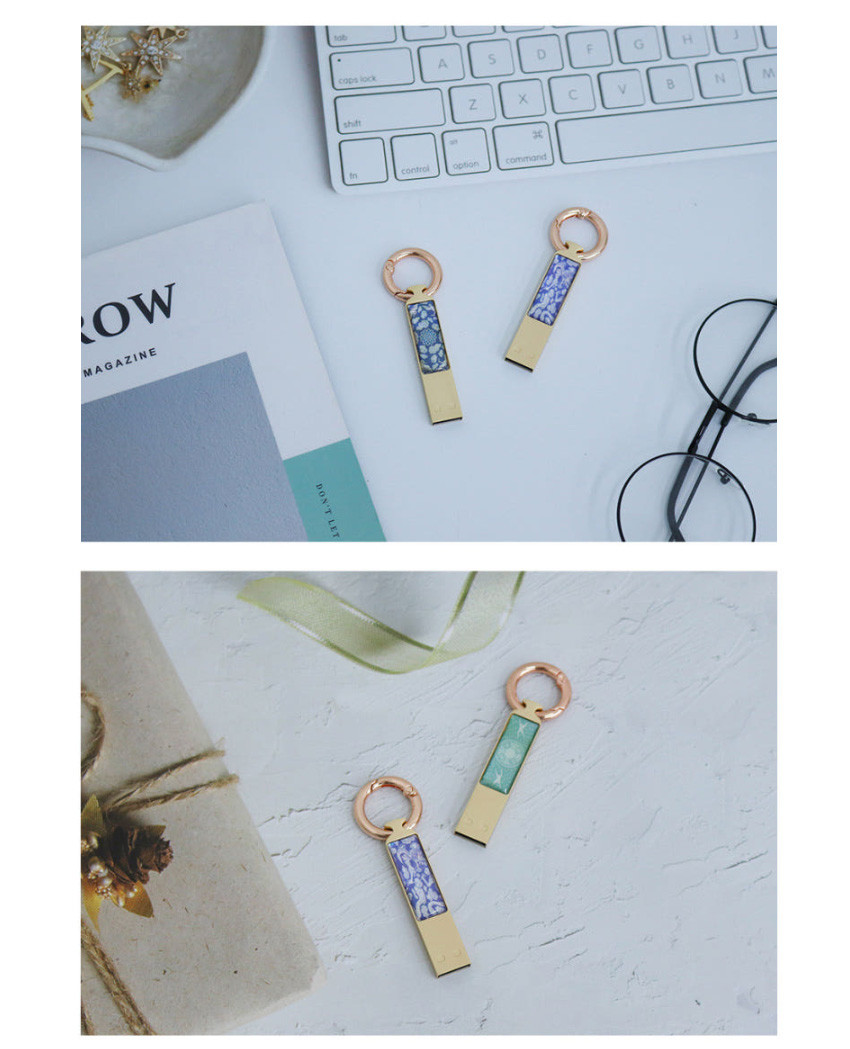 [텍스트: ROW] 금속 바디 위 청자색과 보라색 계열 자개 상감, 구름과 학 문양이 들어간 열쇠고리형 USB 디자인