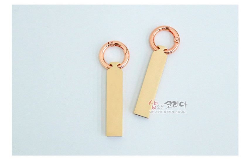 [텍스트: 샵오브코리아 대한민국의 품격까지 전합니다.] 골드 톤 금속 바디와 로즈골드 링이 조합된 직사각형 열쇠고리형 USB 기본 형태 이미지 표현