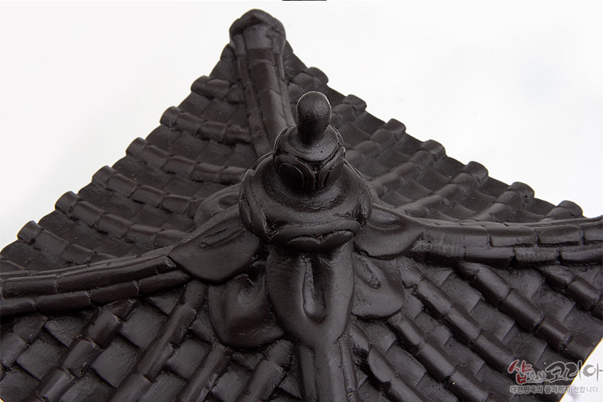 [텍스트: 샵오브코리아 대한민국의 품격까지 전해드립니다.] 검은색 기와지붕 상부를 사실적으로 조각한 전통 한옥 지붕 장식, 중앙 마루와 용마루 장식이 입체적으로 표현된 조형 디테일