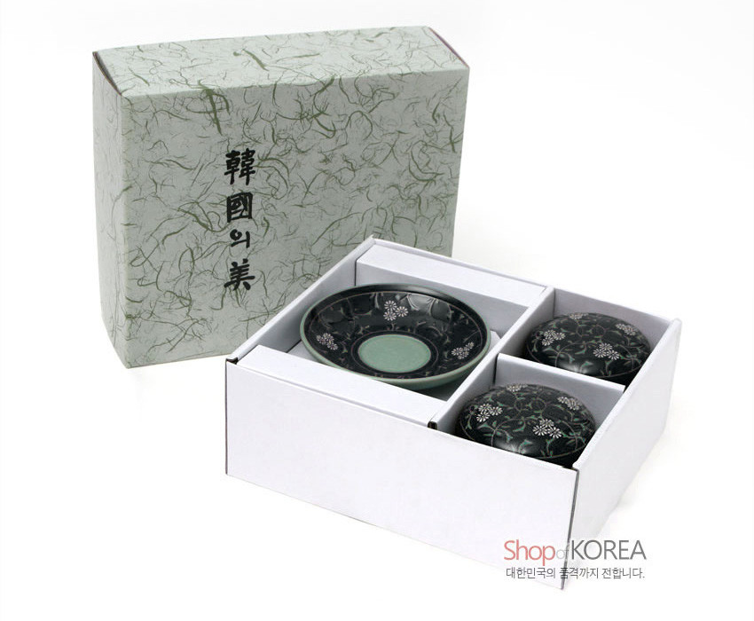 [텍스트: 韓國의 美, Shop of KOREA, 대한민국의 품격까지 전합니다.] 짙은 흑유 바탕에 백색 국화와 연녹색 덩굴무늬를 상감한 청자 다기잔과 받침 포장 세트 이미지