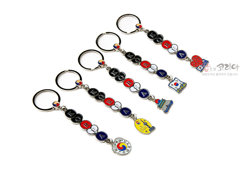 [텍스트: KOREA, shop OF KOREA, 대한민국의 품격까지 전합니다] 금속 재질에 태극삼색 에나멜 채색으로 ‘KOREA’ 알파벳 장식과 태극·태극기·전통문양 펜던트를 더한 열쇠고리 5종 세트 이미지 설명
