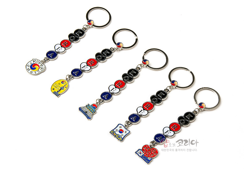 [텍스트: Korea, I LOVE KOREA] 금속 재질에 태극 문양과 ‘KOREA’ 알파벳을 컬러 에나멜로 채운 동전형 장식과 한국 상징 모티브 펜던트 구성 열쇠고리 5종 세트 이미지 설명