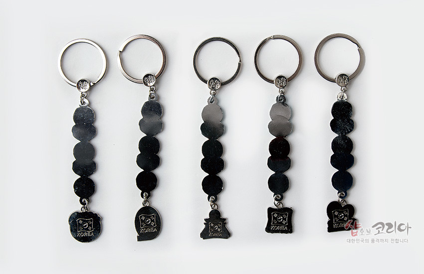 [텍스트: KOREA, 샵오브코리아 대한민국의 품격까지 전합니다.] 금속 재질의 원형 연결 장식 아래 태극 문양과 KOREA 글자를 새긴 펜던트가 달린 열쇠고리 5종 세트 이미지 설명