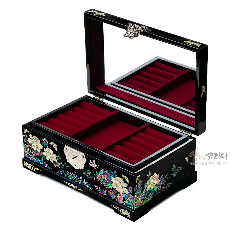 [텍스트: 샵오브코리아 대한민국의 품격까지 전합니다.] 흑색 옻칠 표면에 자개 상감으로 목단과 나비 문양을 장식하고, 내부는 붉은 벨벳으로 구획된 직사각형 보석함 형태