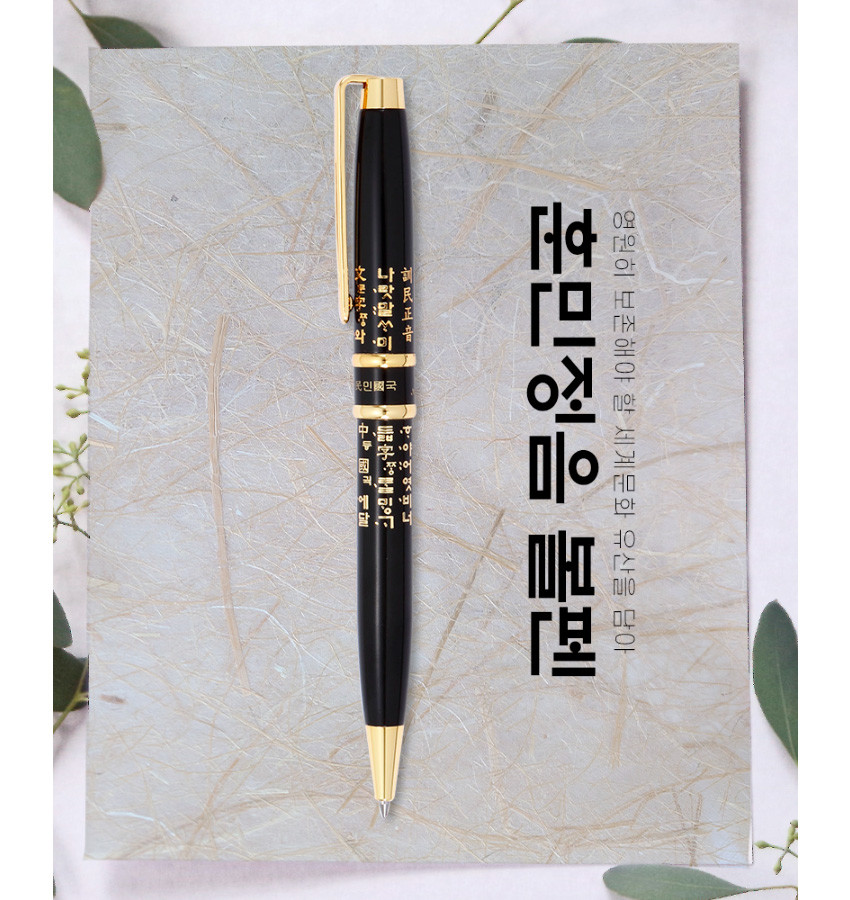 [텍스트: 훈민정음, 영원히 보존해야 할 세종대왕의 문화 유산인 훈민정음] 검은색 바디 위 금속 골드 장식과 클립, 한글 훈민정음 서체 금색 인쇄 문양이 어우러진 볼펜 디자인