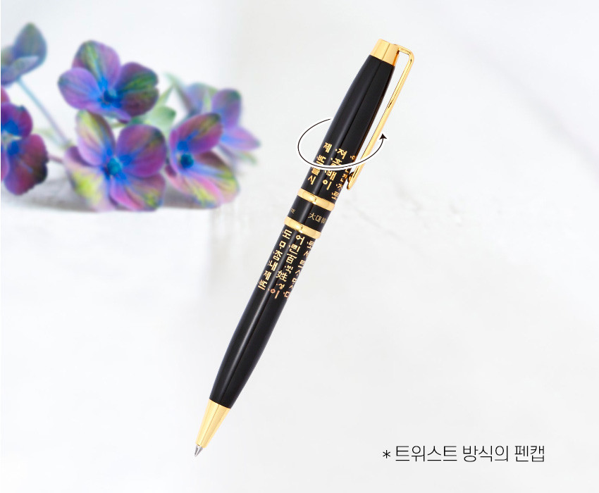 [텍스트: * 트위스트 방식의 펜캡] 검은색 바디와 금속 골드 장식이 조화를 이루고, 한글 훈민정음 금색 문자 문양이 빼곡히 인쇄된 트위스트 방식 볼펜 디자인