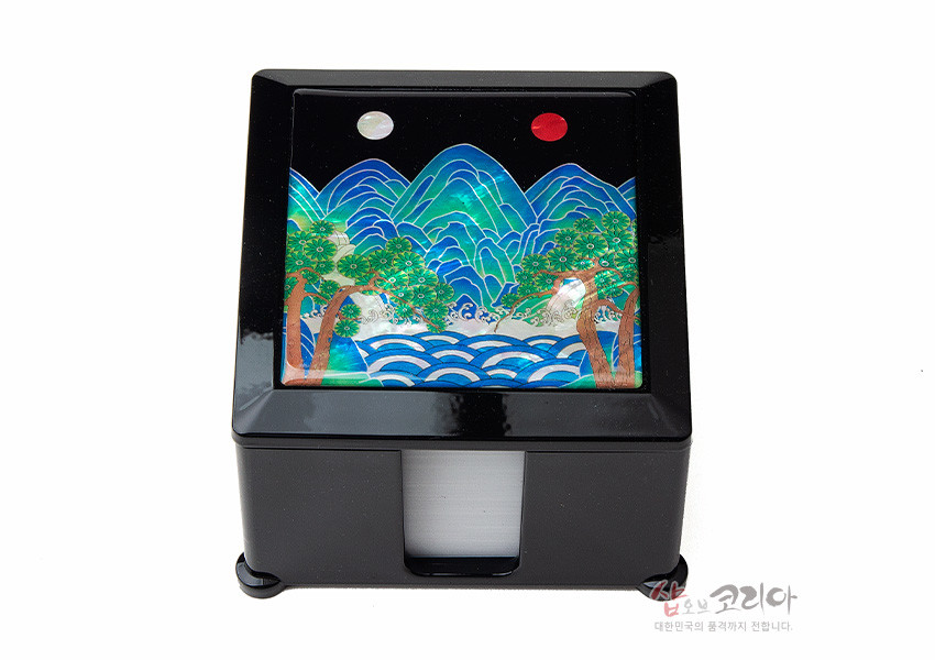 [텍스트: 샵오브코리아 대한민국의 품격까지 전합니다.] 검은 옻칠 사각 메모지함 상단에 자개 상감 기법으로 표현한 청록색 일월오봉도 산수와 푸른 파도, 적색·백색 해와 달 문양이 조화를 이룬 디자인