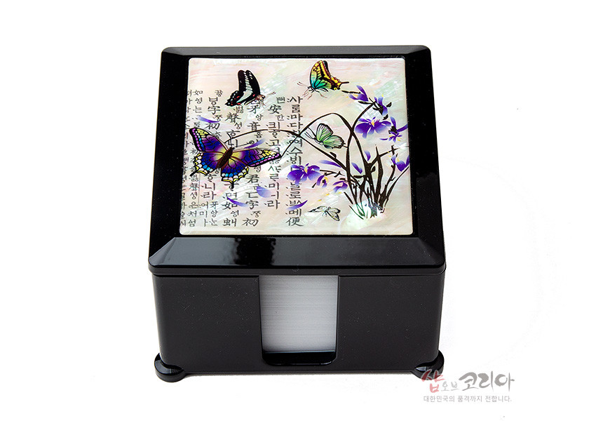 [텍스트: 사람마다 타향을 눈물로 떠나 / 그리운 고향길을 떠오르며 / 유랑객의 설움에 가슴 미어지다] 흑색 옻칠 위 진주빛 자개 상감으로 난초와 나비, 한글 서체 문양을 장식한 사각 메모지함