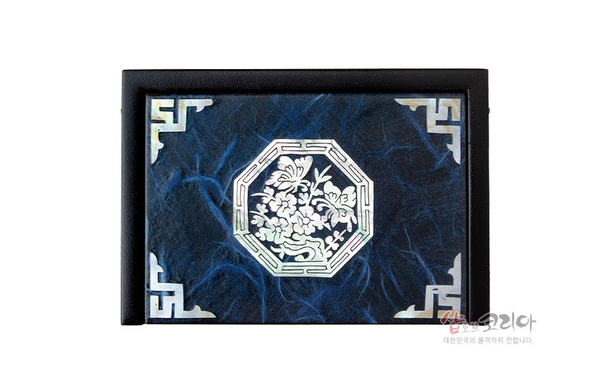 [텍스트: 샵오브코리아 대한민국의 품격까지 전합니다.] 청색 한지 바탕 위 팔각형 자개 청매화 문양과 모서리 전통 기하학 자개 장식이 조화를 이룬 필함 상단 디자인