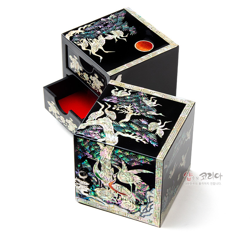[텍스트: 샵오브코리아 대한민국의 문화를 전세계가 전달합니다.] 흑색 옻칠 바탕에 자개 상감으로 송학도와 소나무, 해와 구름을 섬세하게 표현한 사각 쌍합 내부 적색 마감 디자인