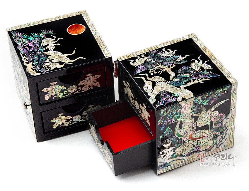 [텍스트: 샵오브코리아 대한민국의 품격까지 전합니다.] 흑색 옻칠 바탕 위에 자개 상감 기법으로 송학도와 소나무, 구름 문양을 섬세하게 표현한 사각 쌍합, 안감 붉은 색 대비가 돋보이는 디자인